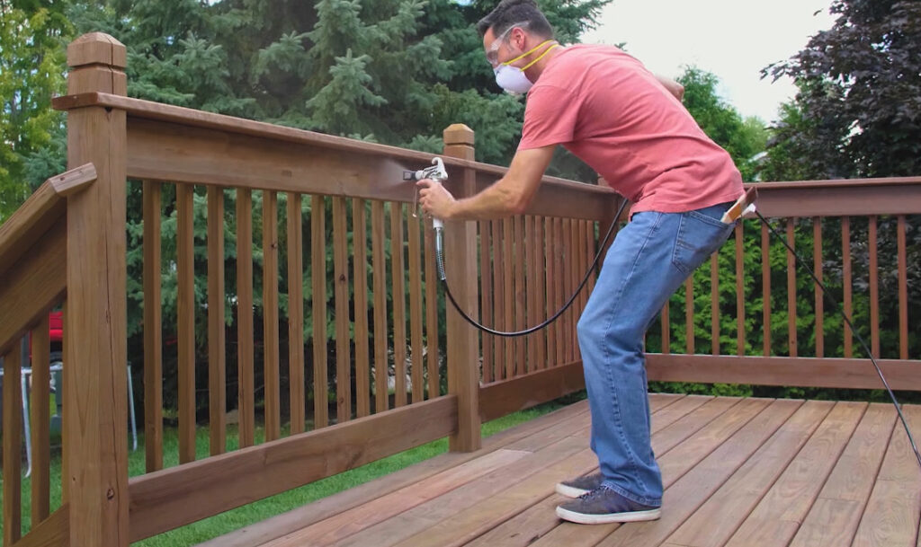 applying stain to deck railings